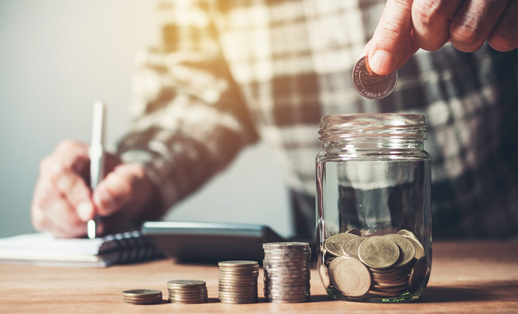 Placing coins in a jar of savings