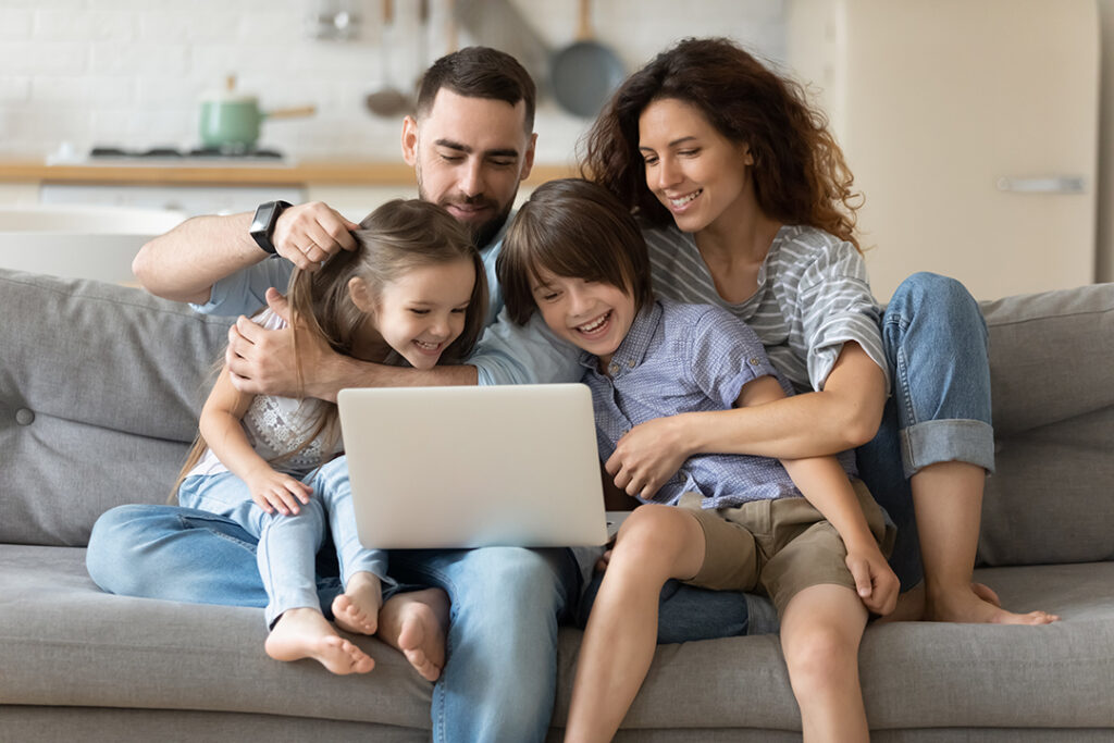 Family of four around computer